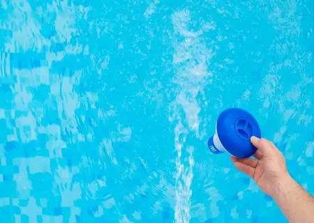 Mano sosteniendo un cartucho de filtro en agua de piscina, categor&iacute;a filtraci&oacute;n de agua